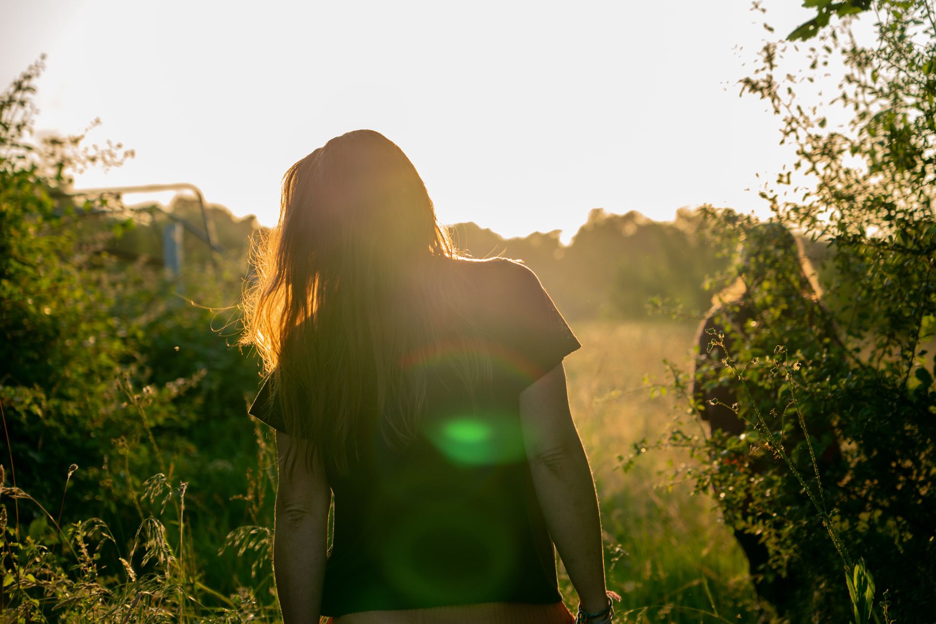 Femme de dos dans la nature au coucher du soleil, cadre d'accompagnement doula en Dordogne