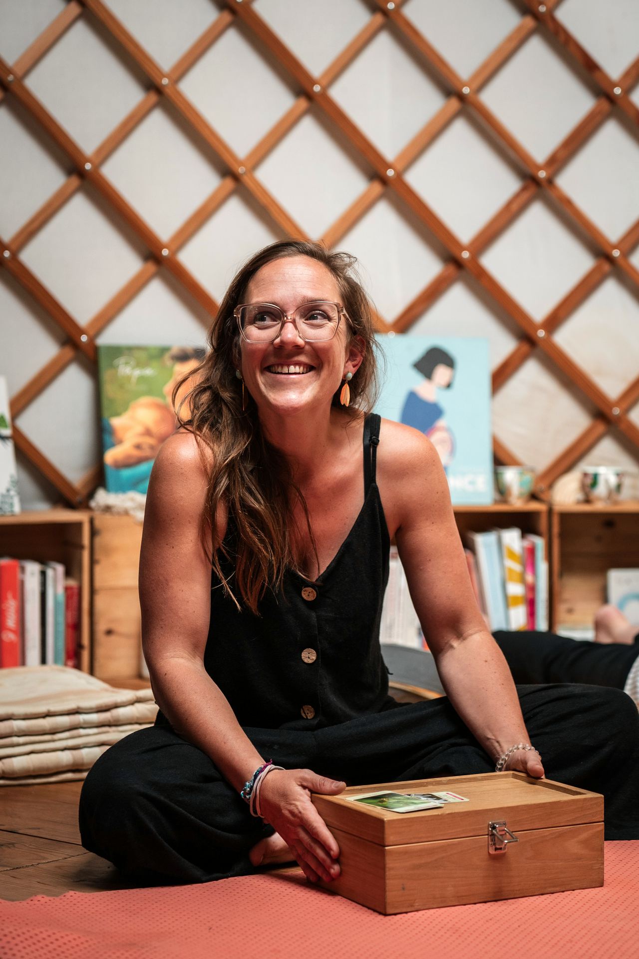 Hannah Stiegler souriante dans la yourte avec le coffret en bois des élixirs de Fleurs de Bach