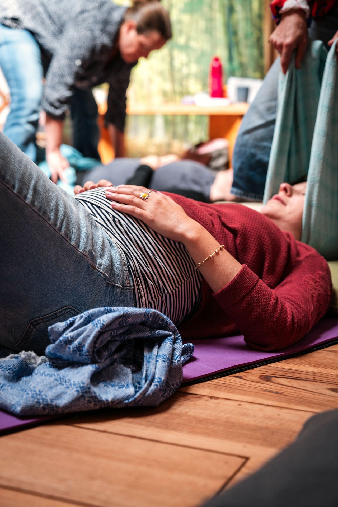Femme enceinte allongée recevant un massage lors d'un atelier dans la yourte